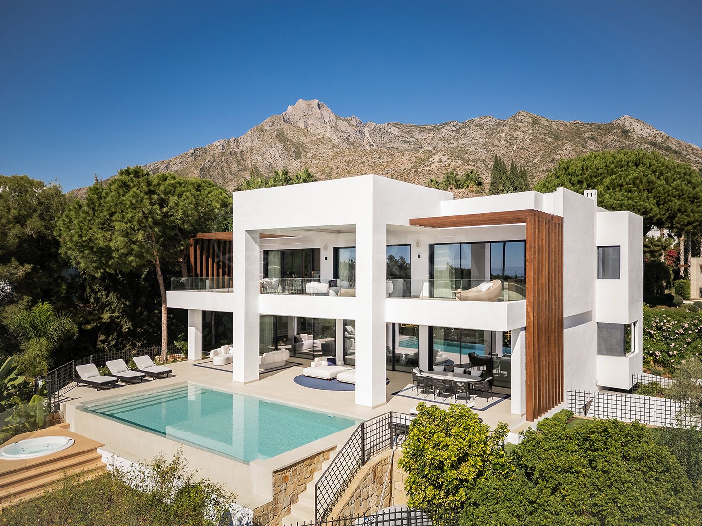 Modern white villa with mountain backdrop and pool
